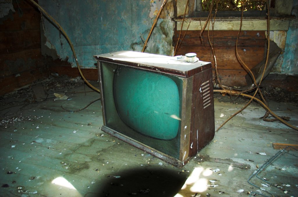 Old television set floating in damaged room