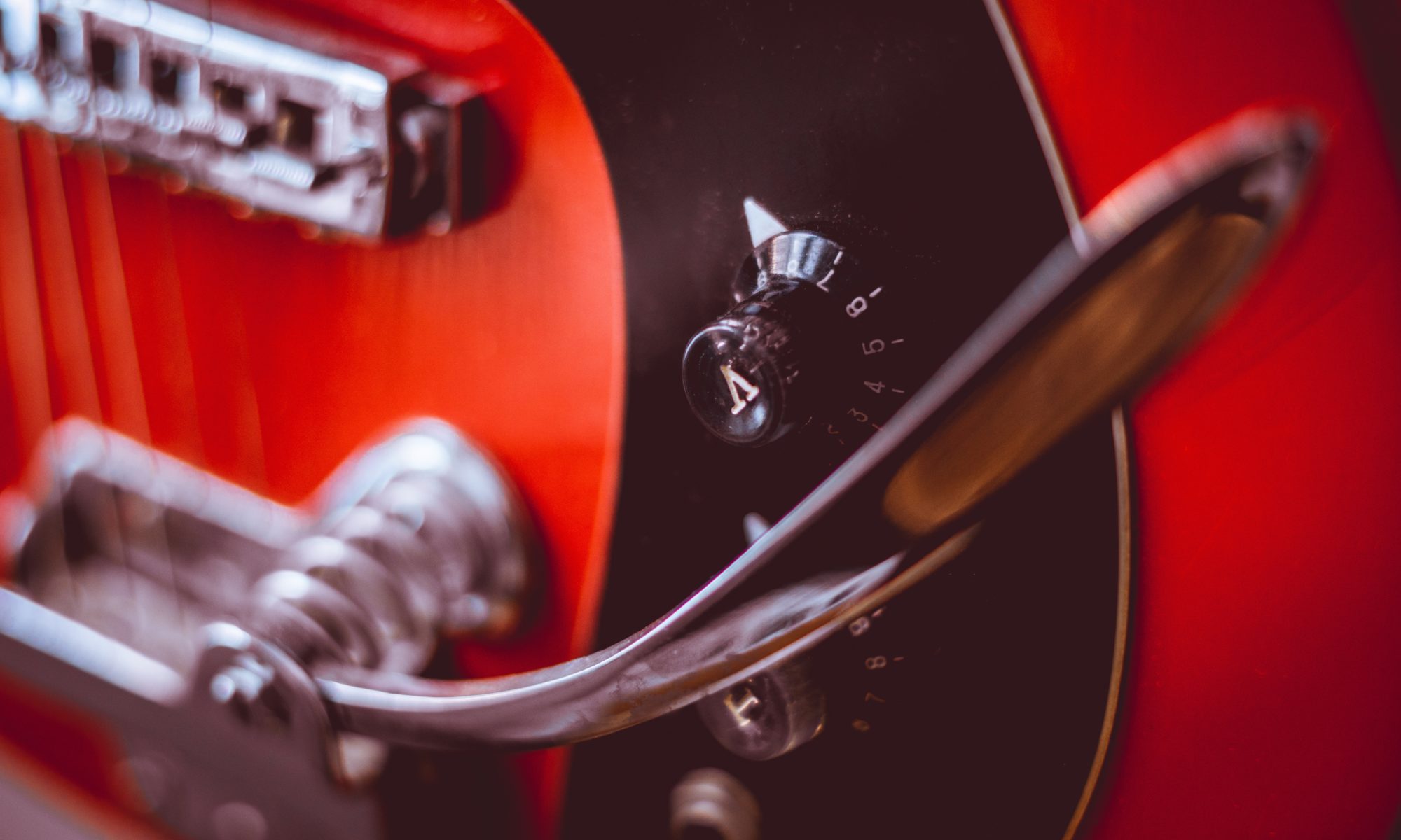 A close up of a red and black electric guitar.