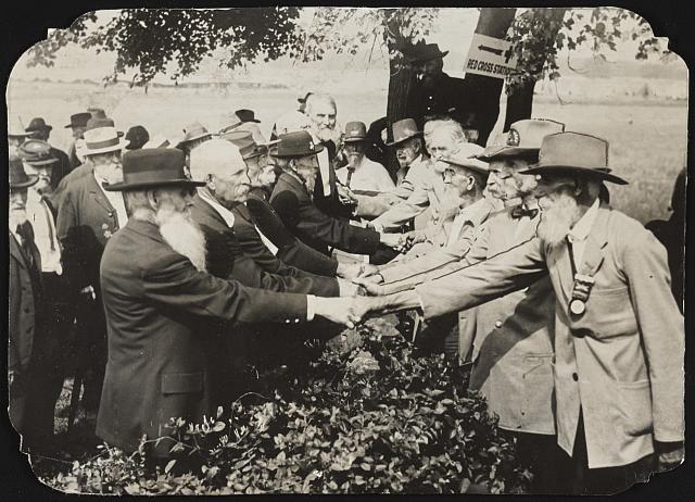 Union and Confederate veterans of the Civil War shake hands at a reunion to mark the 50th anniversary of the end of the war