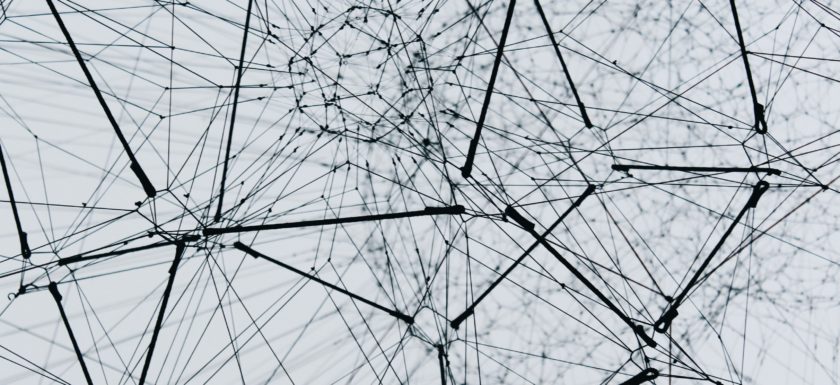 Low-angle photography of black metal structure on a grey background, showing a lot of different connections within the structure.