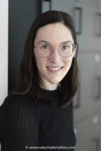 Photograph of a woman with brown hair and glasses