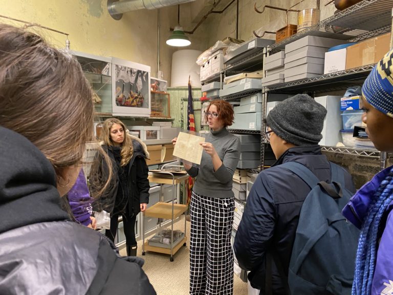Photo of Erica Harman giving students a tour of the archives at ESP