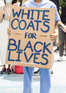 protest sign that reads "white coats for black lives"