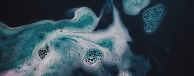 abstract macro photo of water and bubbles, dark blue-green and white