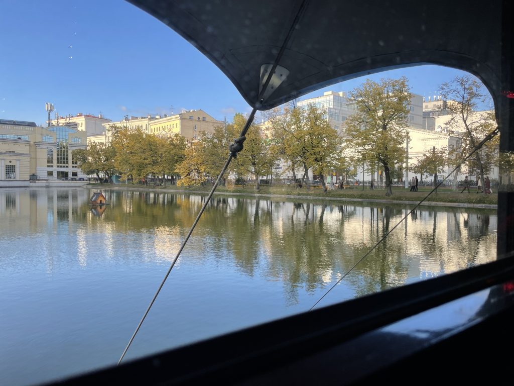A view of the same pond as the previous photo from inside a restaurant built over the water. The shot is framed by the widowsill at bottom and the roof overhang at top.