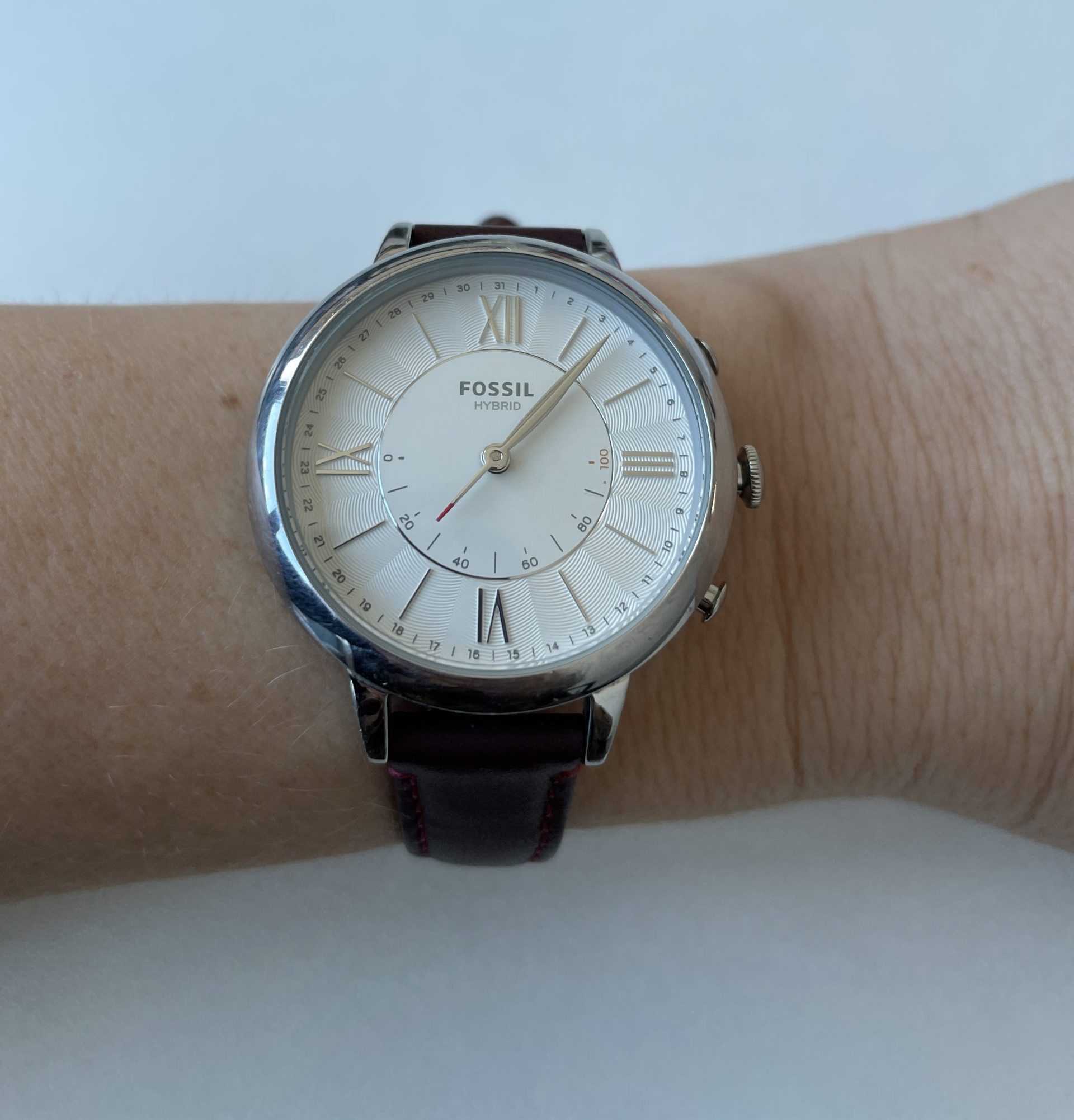 An analog watch on a woman’s wrist indicates that she is 25% toward her movement goal that day.