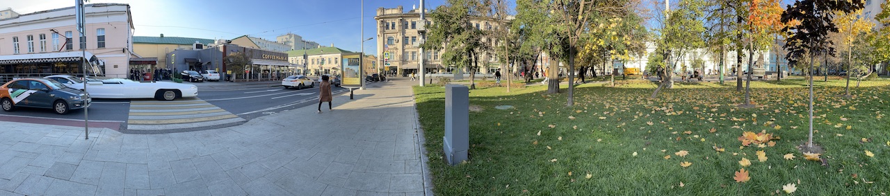 A panoramic view of a street and a park. There are no gates anywhere.