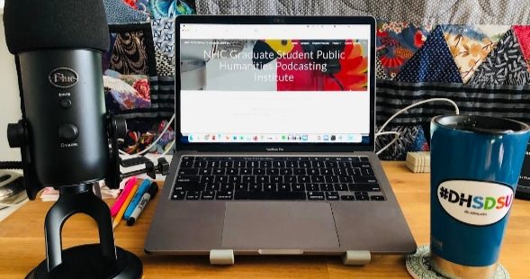 Laptop, podcasting mic, and coffee mug